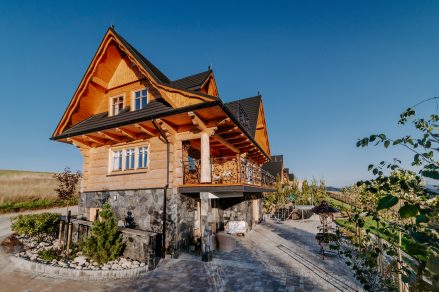 Drewniana chata z kamiennym parterem i rzeźbionym balkonem